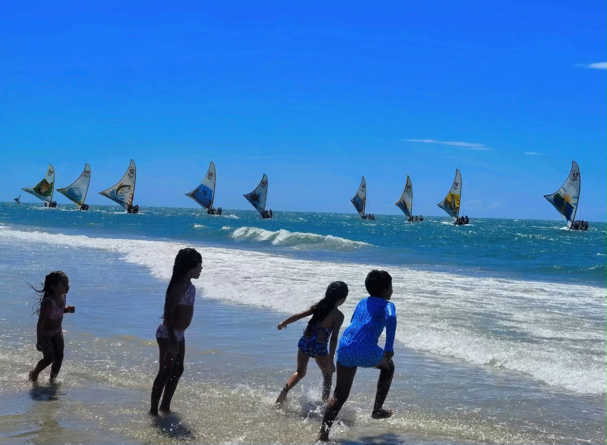 Enfants au bord de l'eau regardant la flotte de jangadas en course