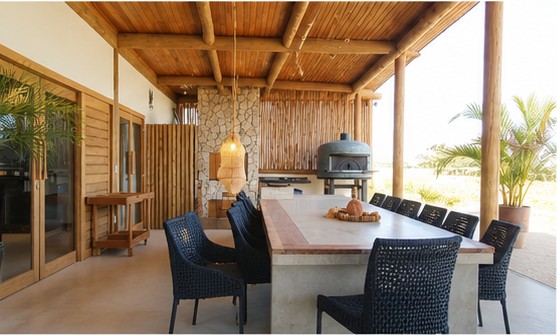 Cuisine extérieure et grande table à manger sous la coursive en bois